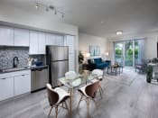 Thumbnail 11 of 12 - a kitchen and living room with white cabinets and stainless steel appliances at Saba Pompano Beach, Pompano Beach, 33062