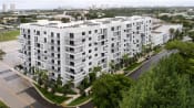 Thumbnail 1 of 12 - an aerial view of an apartment complex with trees in the foreground and a city in the background at Saba Pompano Beach, Florida, 33062