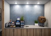 Thumbnail 18 of 35 - a lobby with a coffee machine and a wall with a blue patterned wall paper