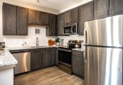 Thumbnail 2 of 35 - a kitchen with dark cabinets and stainless steel appliances