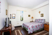 Thumbnail 7 of 12 - bedroom with large window, hardwood-style flooring, and model furnishings