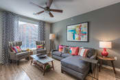 Thumbnail 71 of 78 - a living room with gray walls and a ceiling fan  at EdgeWater at City Center, Lenexa, KS, 66219