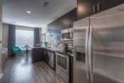 Thumbnail 57 of 78 - a kitchen with stainless steel appliances and a wooden floor  at EdgeWater at City Center, Lenexa, KS, 66219