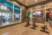 Thumbnail 48 of 78 - the gym with stationary bikes and a tv  at EdgeWater at City Center, Lenexa