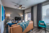 Thumbnail 60 of 78 - a living room with gray walls and a ceiling fan  at EdgeWater at City Center, Lenexa, KS, 66219