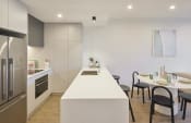 Thumbnail 11 of 29 - a kitchen and dining area with a white counter top