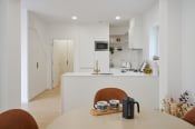 Thumbnail 6 of 28 - a kitchen with white walls and white countertops and a white island with a white countertop