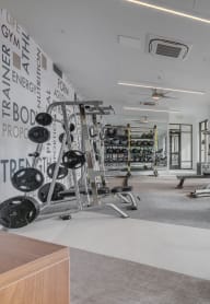 a gym with cardio equipment and windows with a view of the water