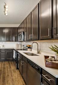 A modern kitchen with dark wood cabinets and a white island.