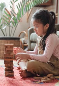 a boy and girl playing with wooden blocks on the floor at Union Arms, Washington, 98122
