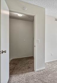 A white closet with a bench and a hanger.