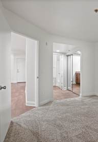 A white closet with a bench and a hanger.