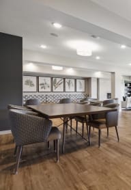 A modern dining room with a wooden table and chairs at Sonder Point 50+ Apartments, Brooklyn Center, MN, 55430