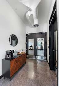 A modern kitchen with a black countertop and a wooden cabinet.