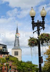 a city street with a church in the background and the word reach at 605 Concord at Fresh Pond Apartments, Cambridge, MA, 02138