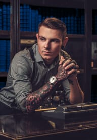a man with a tattoo on his arm sitting at a desk in a library at Altis Grand Central Apartments in Tampa, FL