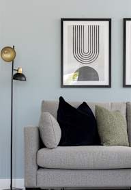 a dining room with a wooden table and blue chairs and a blue wall with artwork