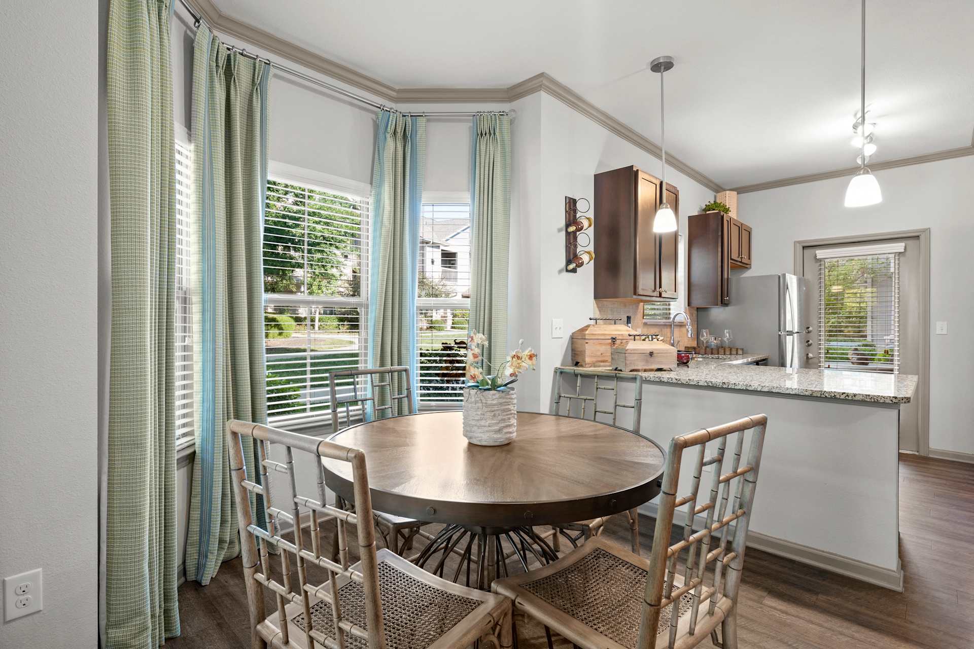 Kitchen with a table and chairs in front of a window at Stonepost Crossing Apartments