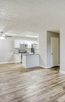 A kitchen with a granite countertop and white cabinets.