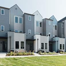 A modern building with grey and white exterior and multiple windows.