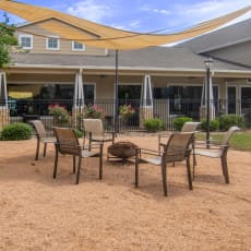 a patio with chairs and umbrellas in front of a building