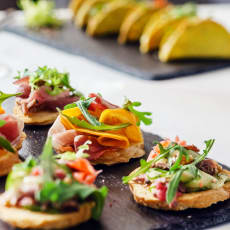 a tray of sandwiches on a table with fruit