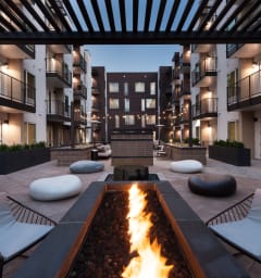 a courtyard with a fire pit and lounge chairs