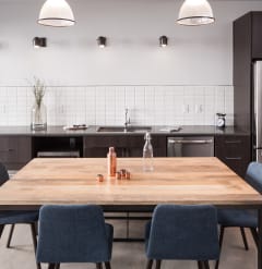 a kitchen with a large wooden table and blue chairs