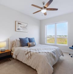 a bedroom with a bed and a ceiling fan