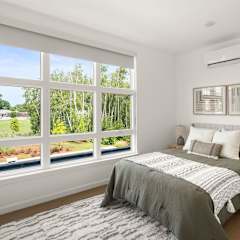 A bedroom with a bed, nightstand, and a painting on the wall.
