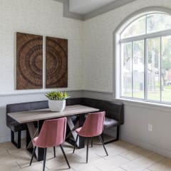 a dining area with a table and chairs and a large window