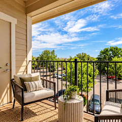 A balcony with a chair and a table with a potted plant on it.