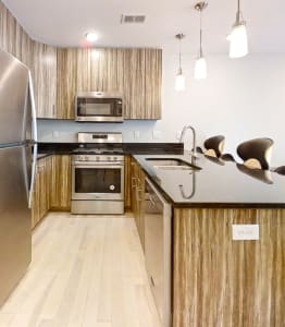 a modern kitchen with stainless steel appliances and wooden cabinets