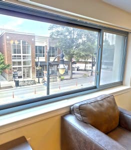 a living room with a large window overlooking a city street