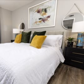 a bedroom with white bedding and yellow and green pillows