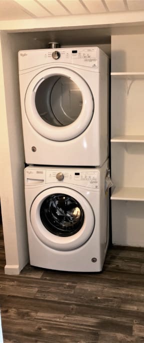 a washer and dryer are stacked on top of each other in a small laundry room
