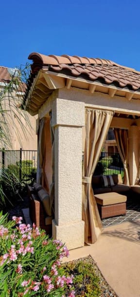 a gazebo with curtains in a garden