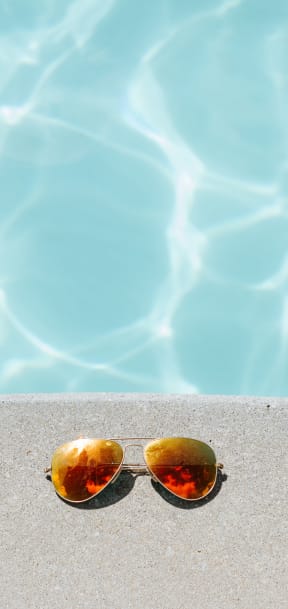 sunglasses on a swimming pool edge