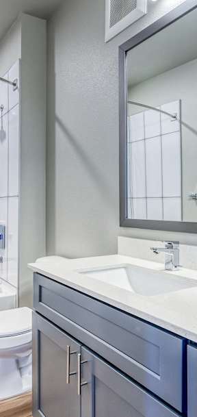 A white toilet sits next to a white sink in a modern bathroom.