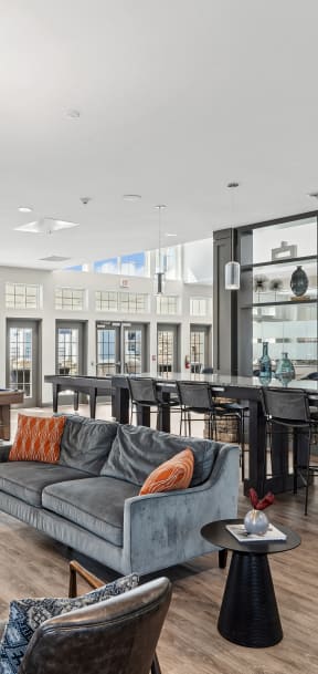 a living room with couches chairs and tables and a bar