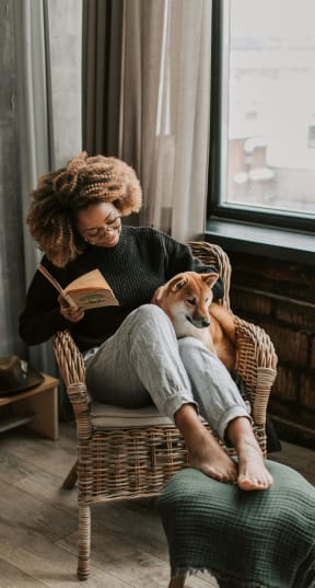 a woman reading a book on a chair  at Crogman School Lofts in Georgia 30315