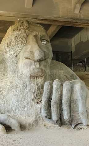 A large stone statue of a lion with its paw on its chest.