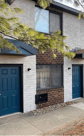 a building with blue doors and a sidewalk in front of it