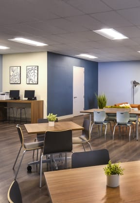 a room with a table and chairs and a television on the wall