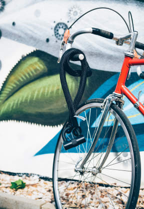 a bike parked in front of a wall with a mural