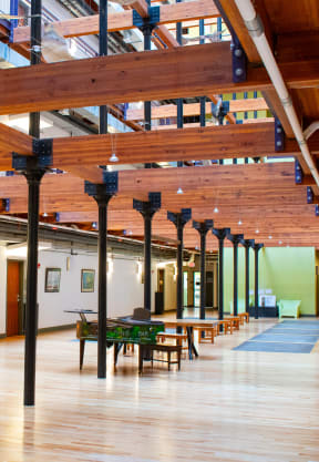 a large room with wooden floors and ceilings and tables and chairs
