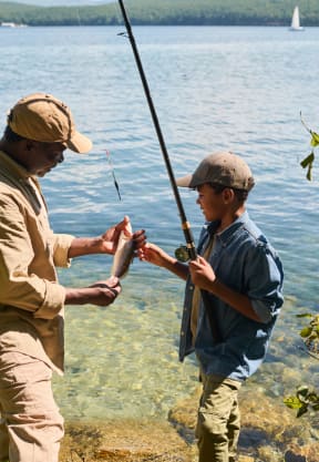 a man and a boy are fishing on the shore of a lake at Village at Terra Bella Apartments, Land O' Lakes, Florida