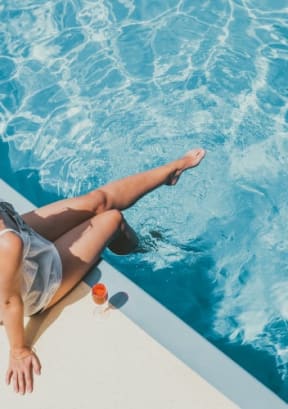 a woman laying on the side of a pool