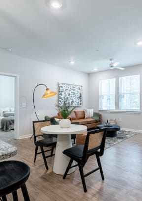 Open living room and dining room with a table and chairs at Waterleaf at Salt Creek apartments in Savannah, GA