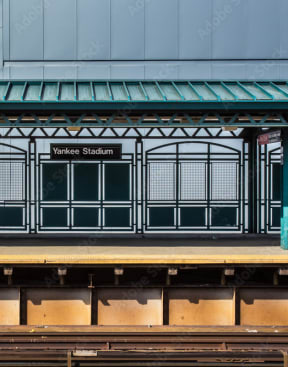 a train station with a platform and a blue building at Clinton Towers, Bronx, NY, 10457